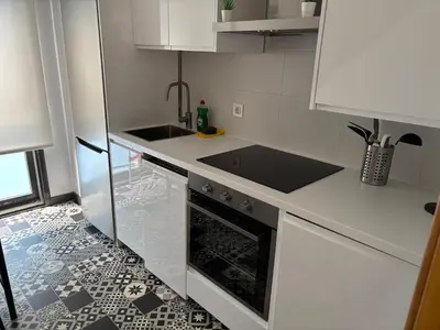 a white kitchen with a sink and a stove at As Mirandas Apartment in Ares