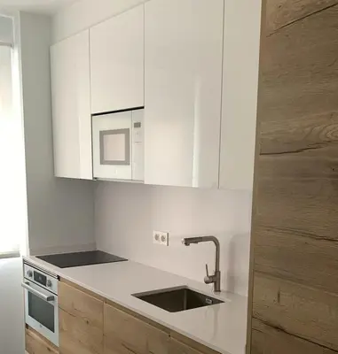 a white kitchen with a sink and a microwave at Apartamento AIIA in Ribadeo