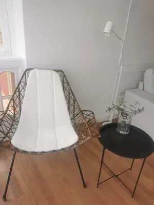 a rattan chair and a table in a room at Apartamento AIIA in Ribadeo