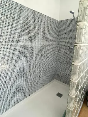 a bathroom with black and white tiled walls and a shower at ÁTICO CON VISTAS Centro Histórico in Allariz
