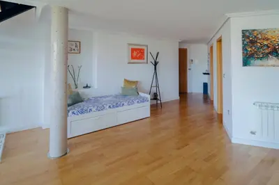 a white room with a bed and a pole at ÁTICO CON VISTAS Centro Histórico in Allariz