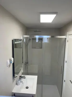 a white bathroom with a shower and a sink at Vivienda turística Ares in Ares