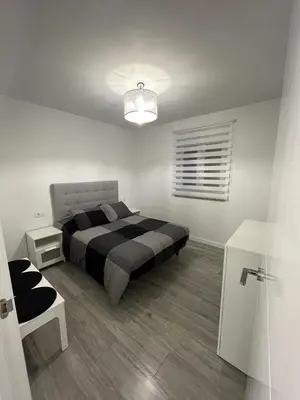 a bedroom with a black and white bed and a table at Vivienda turística Ares in Ares