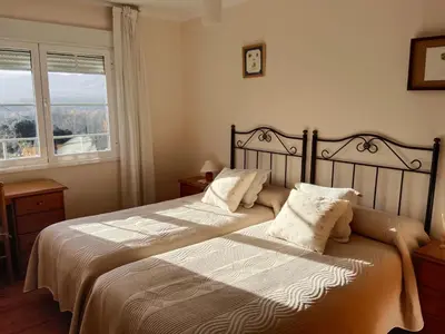 a bedroom with two beds and a window at Casa Macías in Lago de Carucedo