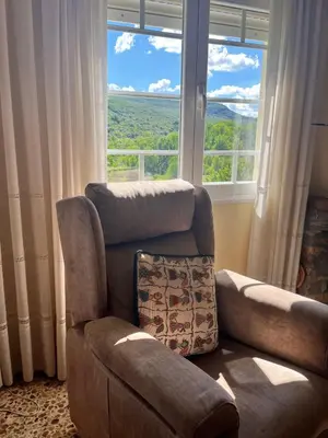 a living room with a couch and a chair and a window at Casa Macías in Lago de Carucedo