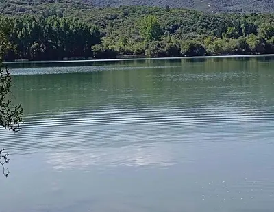 a large body of water with trees in the background at Casa Macías in Lago de Carucedo