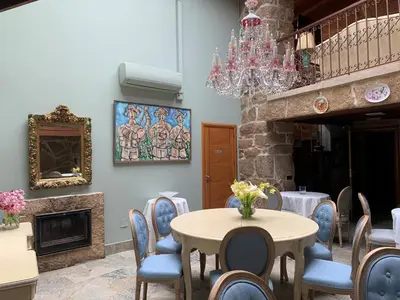 a dining room with a table and chairs and a chandelier at Hotel Rústico San Jaime in Ourense