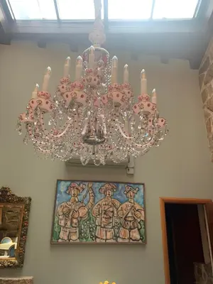 a pink chandelier hanging from a wall with a painting at Hotel Rústico San Jaime in Ourense