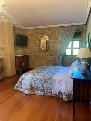 a bedroom with a bed and a mirror and a window at Hotel Rústico San Jaime in Ourense