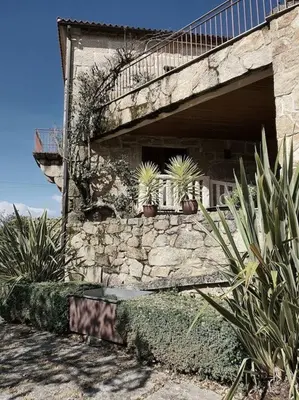 a stone building with a staircase and potted plants at Hotel Rústico San Jaime in Ourense