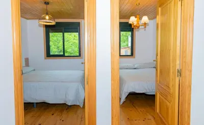 two beds in a room with two windows at Cabana do Sil in Forcas