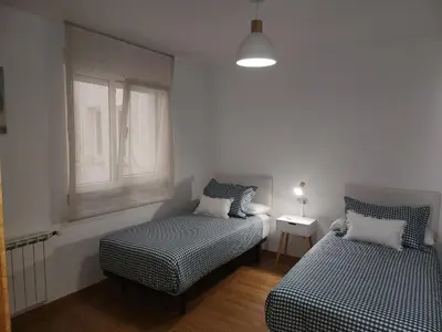a bedroom with two beds and a window at SayCa CREDENCIAL in Sarria