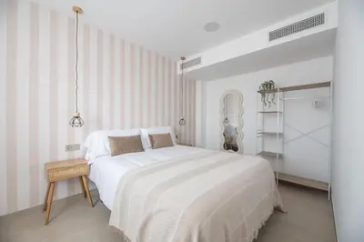 a white bedroom with a large bed and a table at NUBA apartamentos turísticos in Monforte de Lemos