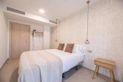 a bedroom with a large white bed in a room at NUBA apartamentos turísticos in Monforte de Lemos