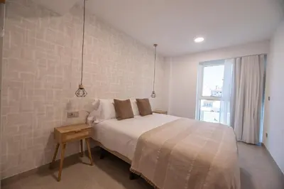 a white bedroom with a bed and a window at NUBA apartamentos turísticos in Monforte de Lemos