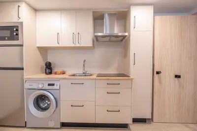 a kitchen with a washing machine and a sink at NUBA apartamentos turísticos in Monforte de Lemos