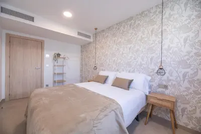 a bedroom with a large bed and a wall with wallpaper at NUBA apartamentos turísticos in Monforte de Lemos