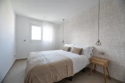 a white bedroom with a large bed and a window at NUBA apartamentos turísticos in Monforte de Lemos