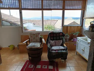 a living room with a chair and a window at Casa Nodar in Chantada