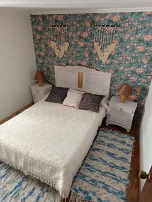 a bedroom with a bed with a floral wallpaper at Casa Nodar in Chantada