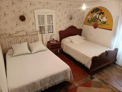 a bedroom with two beds and a painting on the wall at Casa Nodar in Chantada