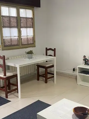 a white table and chairs in a room with a table and windows at Casa Trasande in Couso