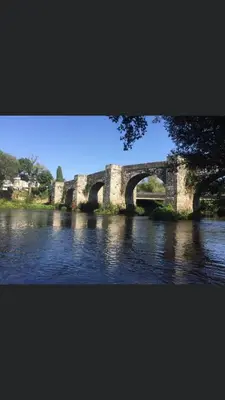 an old stone bridge over a river with water at Casa Trasande in Couso