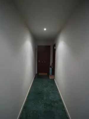 an empty hallway with a door and a green carpet at Apartamento Casco Histórico in Viveiro