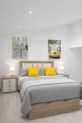 a bedroom with a bed with two yellow pillows at Casa Vidán completa Santiago Rural in Santiago de Compostela