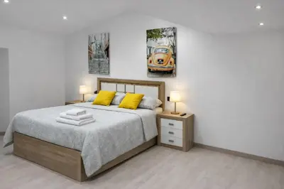 a bedroom with a bed with two yellow pillows at Casa Vidán completa Santiago Rural in Santiago de Compostela