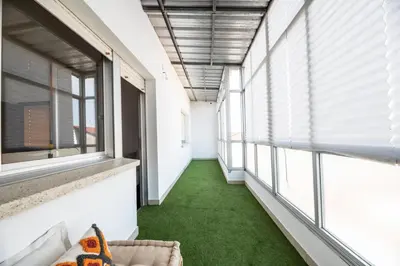 a hallway with green flooring and large windows at Atico centrico con terrazas in Monforte de Lemos