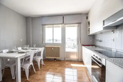 a kitchen with a white table and white chairs at Atico centrico con terrazas in Monforte de Lemos