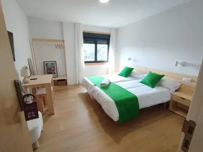 a bedroom with a large bed with green pillows at Hotel Zura in Seoane