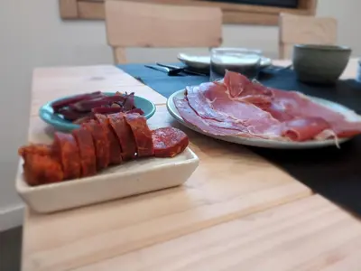 a table with two plates of bacon and meat at Hotel Zura in Seoane