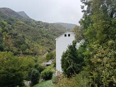 a white building on the side of a mountain at Hotel Zura in Seoane