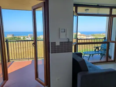 a room with a balcony with a view of the ocean at Praia de llas in Foz