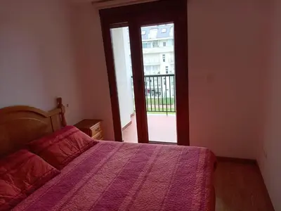 a bedroom with a bed and a door to a balcony at Praia de llas in Foz