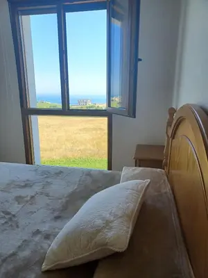 a bedroom with a bed with a large window at Praia de llas in Foz