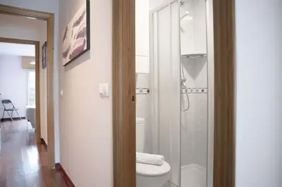 a bathroom with a toilet and a glass shower at Apartamento Mónaco in Santiago de Compostela