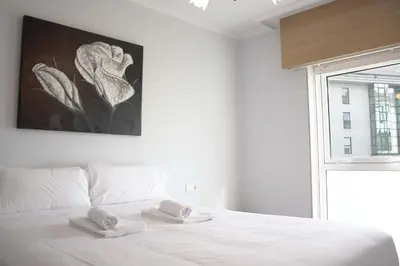 a bedroom with a white bed with two towels on it at Apartamento Mónaco in Santiago de Compostela