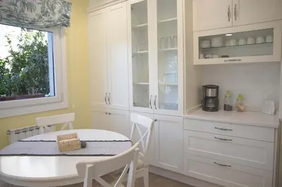 a kitchen with white cabinets and a table with chairs at Casa das Buceleiras in Amés