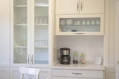 a kitchen with white cabinets and a coffee maker at Casa das Buceleiras in Amés