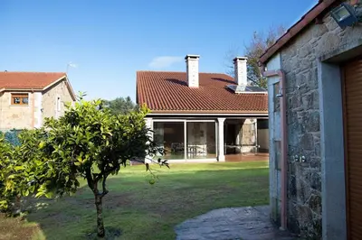 a house with a tree in the yard at Casa das Buceleiras in Amés