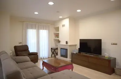 a living room with a couch and a flat screen tv at Casa das Buceleiras in Amés