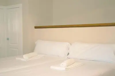 a white bed with two white towels on it at Casa das Buceleiras in Amés