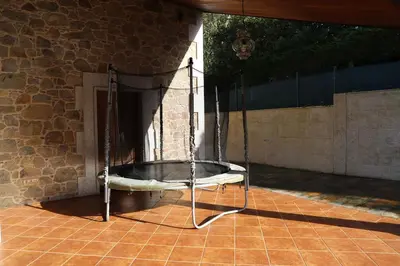 a metal swing on a patio with a stone wall at Casa das Buceleiras in Amés