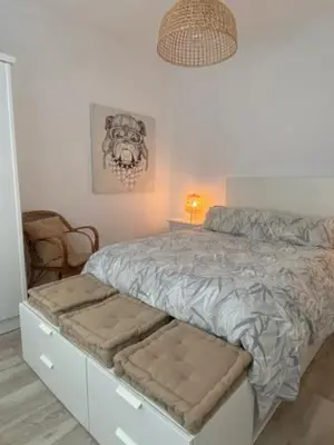 a bedroom with a bed with a bench next to it at O nido de David, un refuxio urbano na Ribeira Sacra in Monforte de Lemos