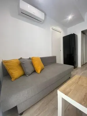 a living room with a gray couch with yellow pillows at O nido de David, un refuxio urbano na Ribeira Sacra in Monforte de Lemos
