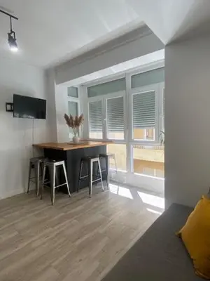 a living room with a table and a large window at O nido de David, un refuxio urbano na Ribeira Sacra in Monforte de Lemos