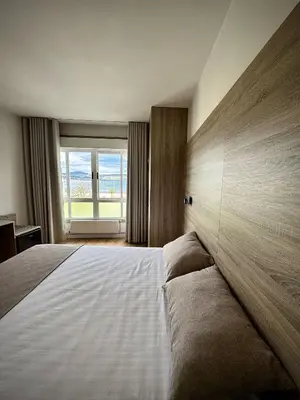 a bedroom with a large bed with a large window at Miramar Suites in Sada